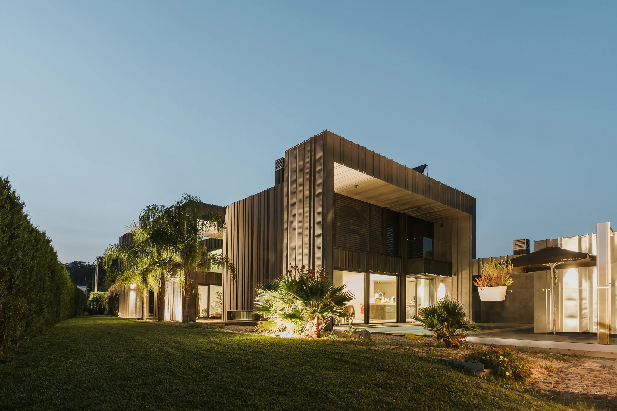 ZN12 House: jardim e fachada ao anoitecer